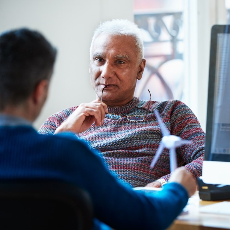 Two men discussing beside a computer